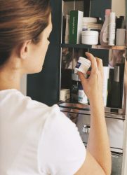 Woman reading label on bottle of aspirin