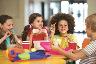 Four children sitting at a lunch table at school