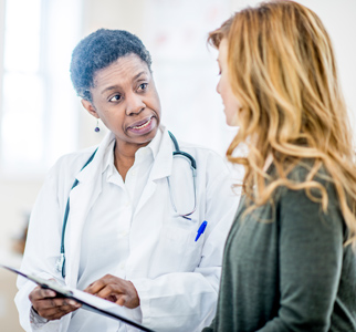 Healthcare provider talking with a younger woman in an exam room