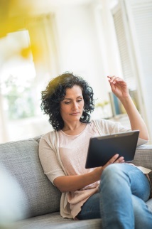 Woman sitting on couch looking at laptop