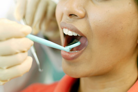 Woman having her teeth examined