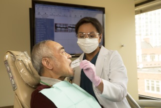Dental professional working on man's mouth