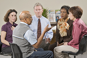 Three women and two men in group meeting.