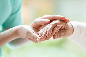Closeup of woman holding other woman's hands.