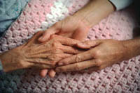Imagen de una anciana y una joven tomadas de la mano