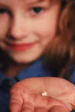 Young girl holding a tooth in her palm